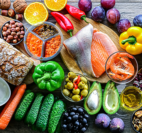 various fresh fruits vegetables seafood and nuts arranged on a wooden surface for healthy cooking two recipes