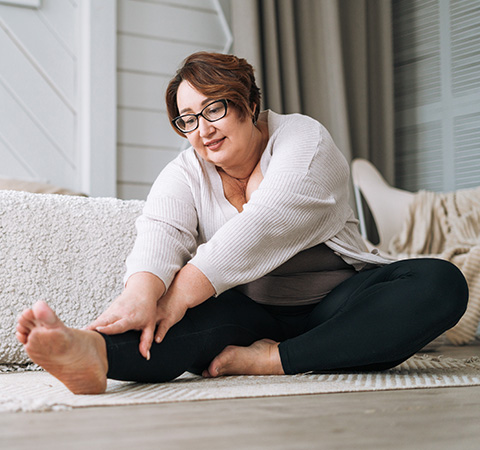 woman practicing yoga stretches on a soft rug in a cozy indoor space enhancing flexibility and wellness